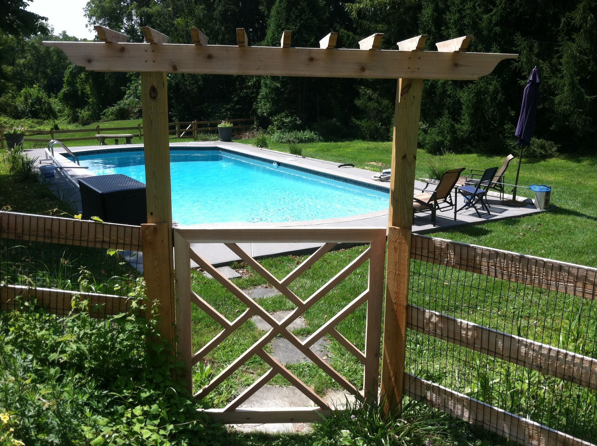 A wooden gate leading to a swimming pool