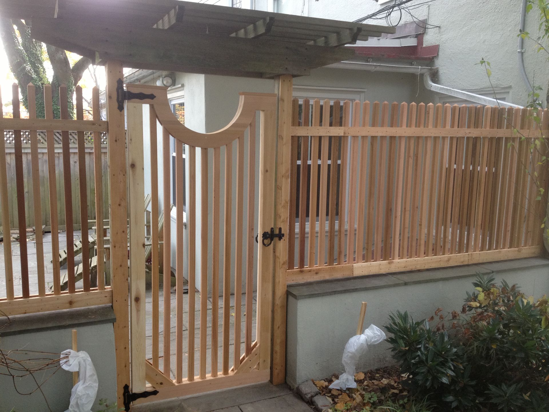 A wooden fence with a gate in front of a house.