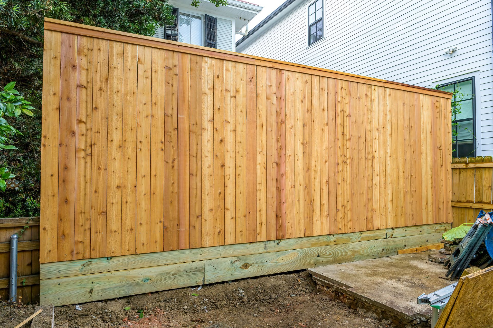A tall cedar privacy fence in the backyard. A tall cedar privacy fence in the backyard.