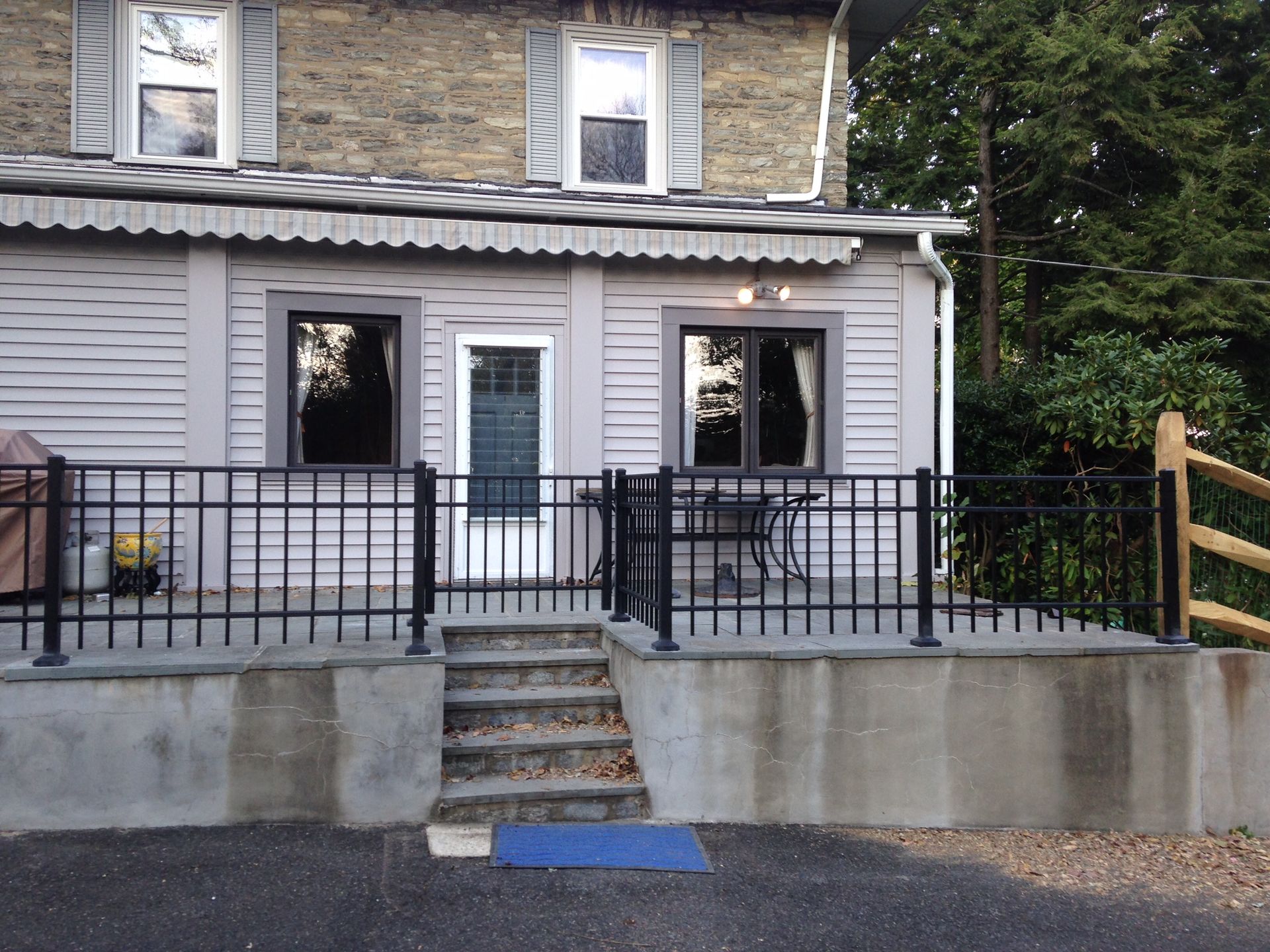 A house with a fence around it and stairs leading up to it