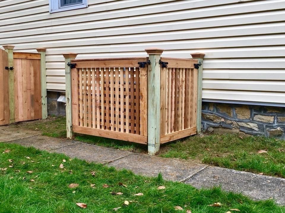 A wooden box is sitting in the grass next to a house.