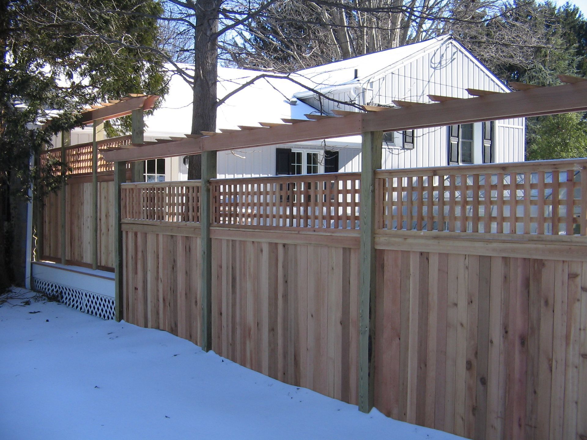 A wooden fence with a pergola on top of it