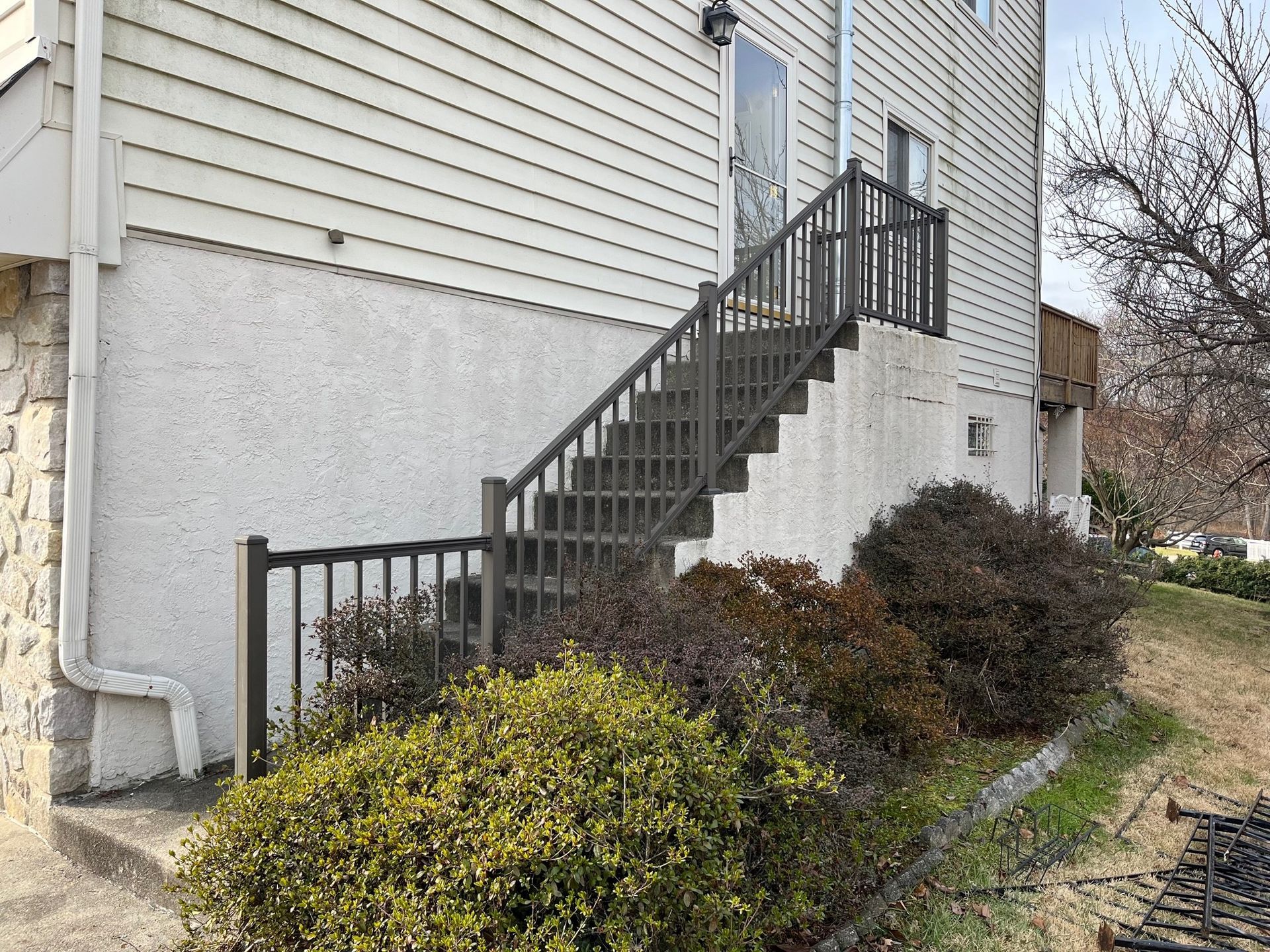 A white house with stairs leading up to the second floor.