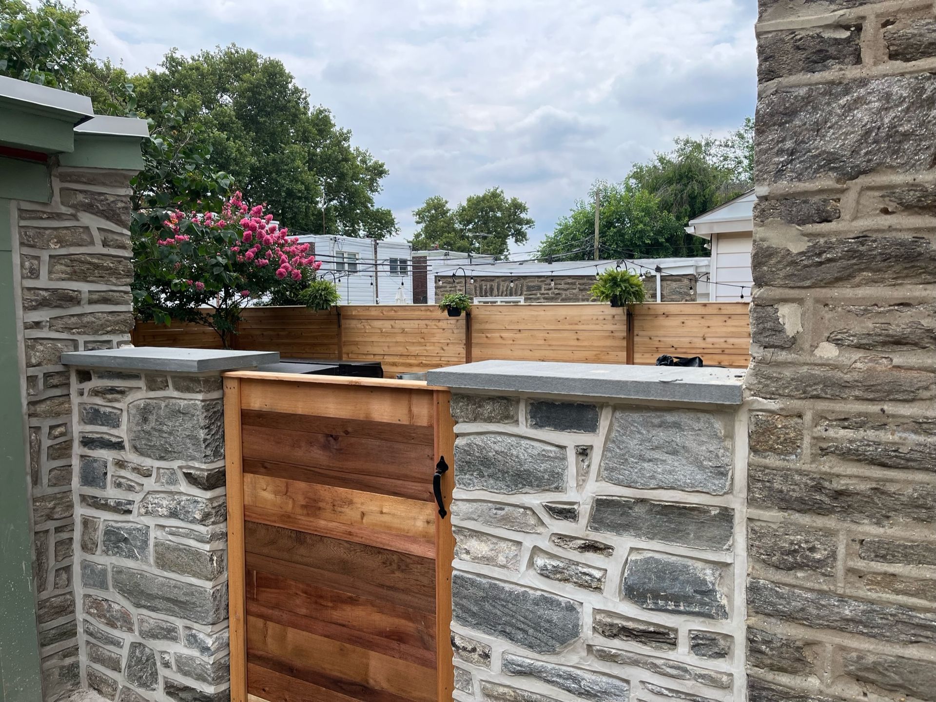 A wooden gate is between two stone walls.