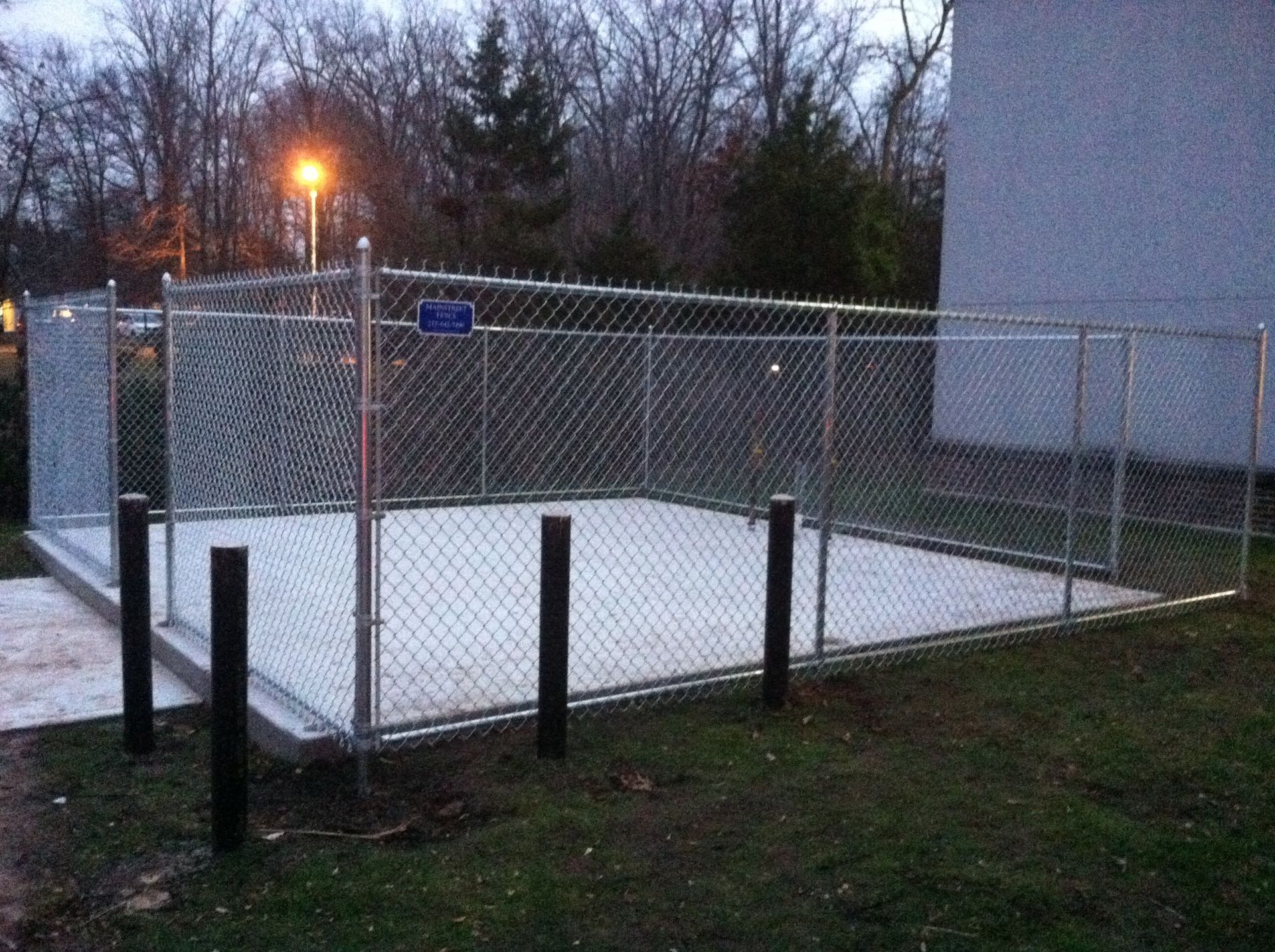 A chain link fence surrounds a concrete area.