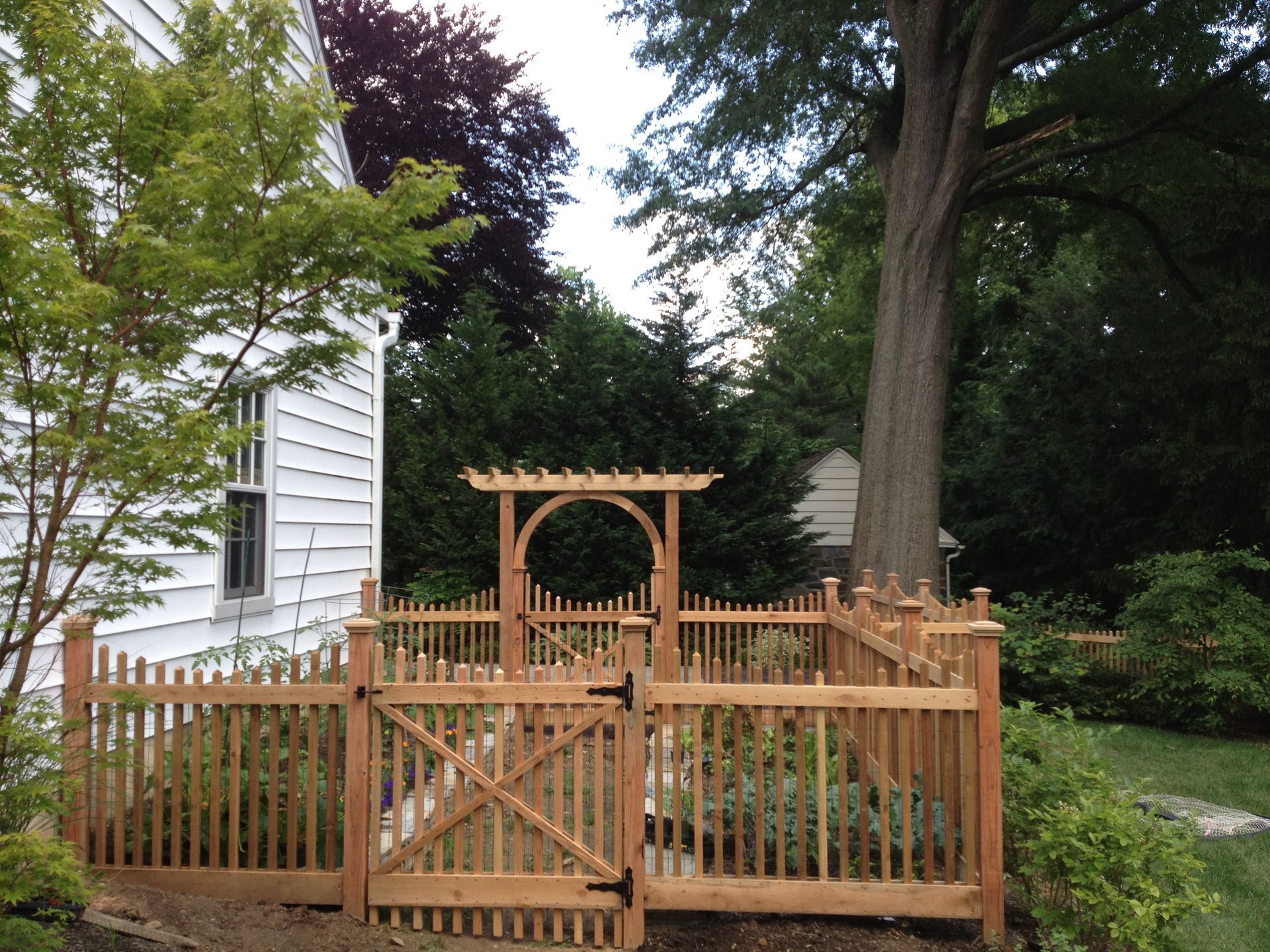 A wooden fence with a gate in front of a house
