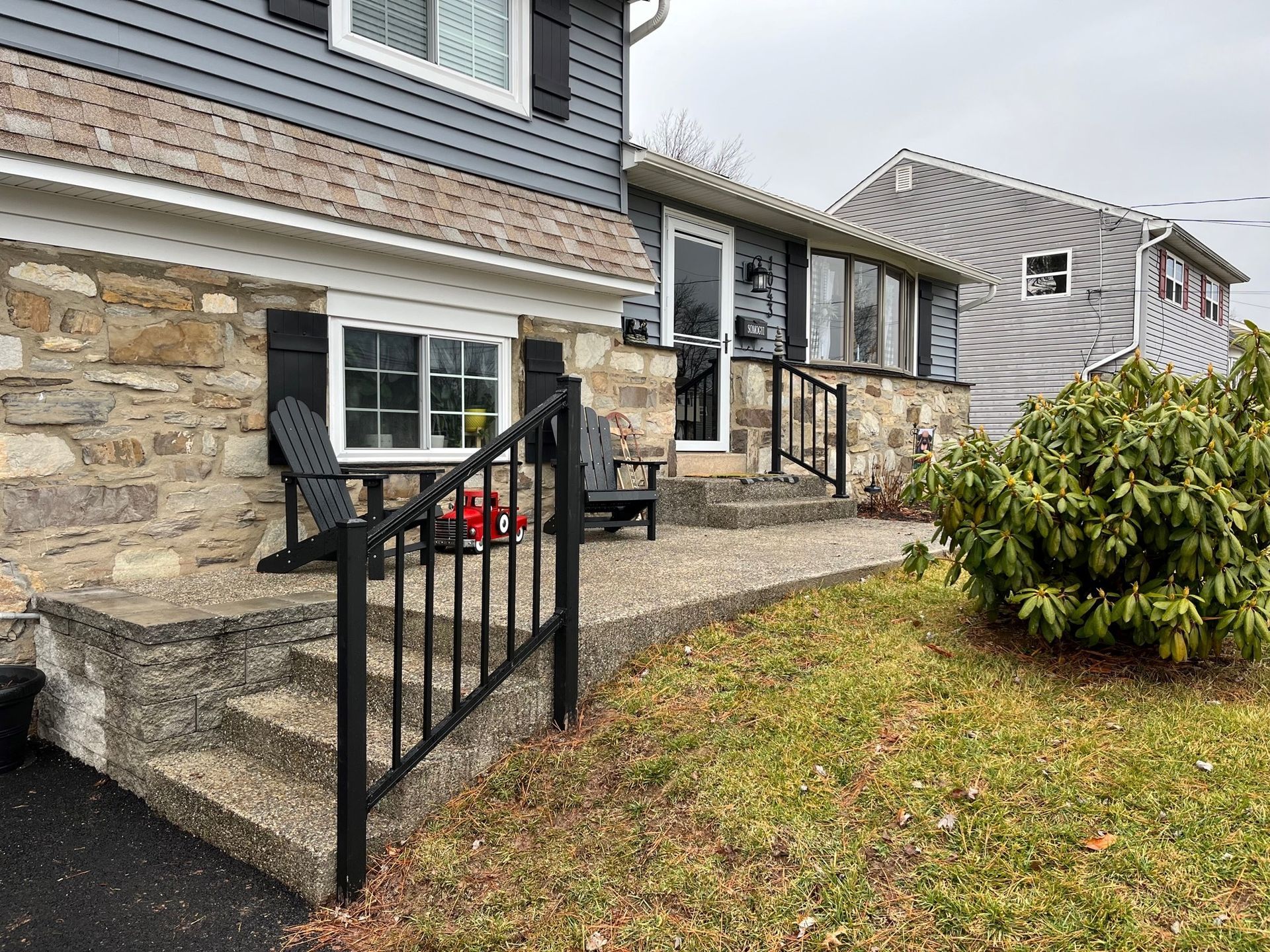 A house with a patio and stairs in front of it.