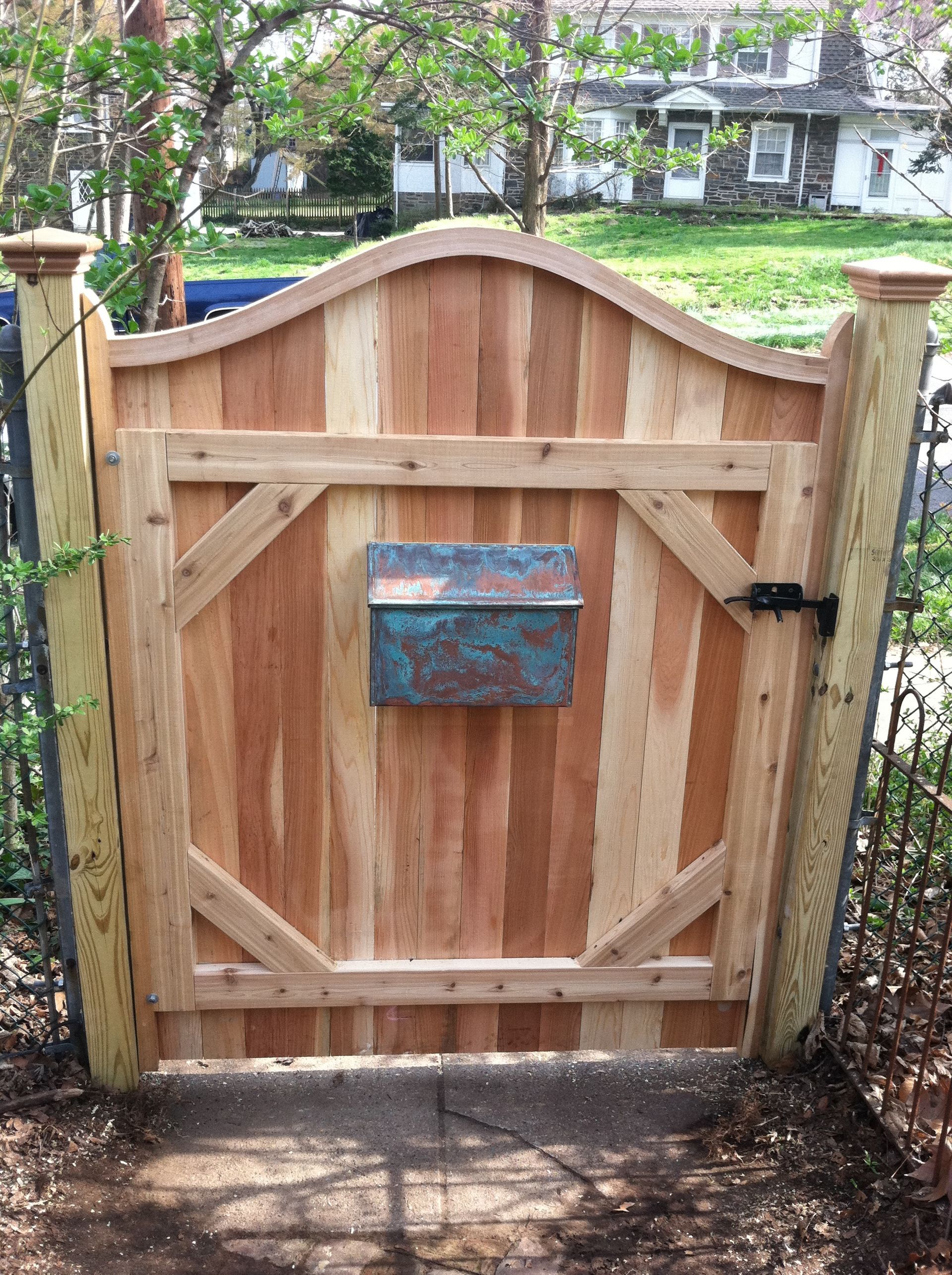 A wooden gate with a mailbox attached to it