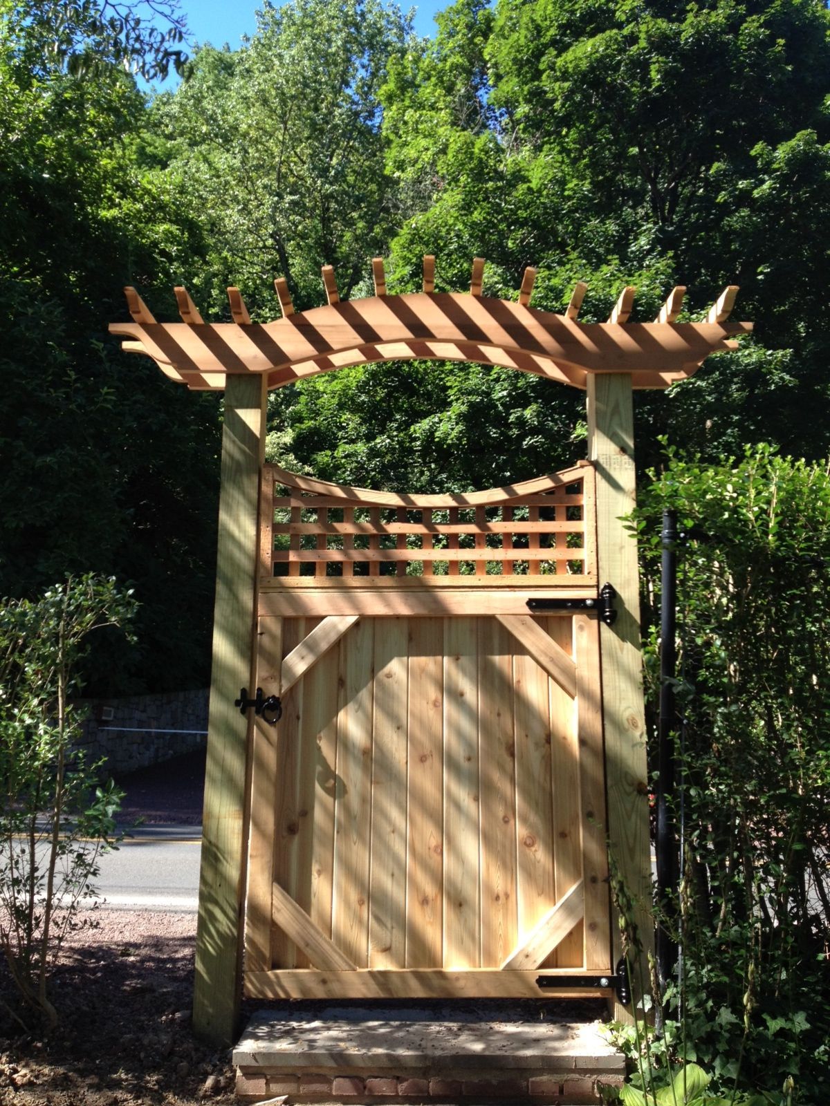 A wooden gate with a pergola on top of it