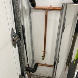 A copper pipe is hanging from a wall in a room.