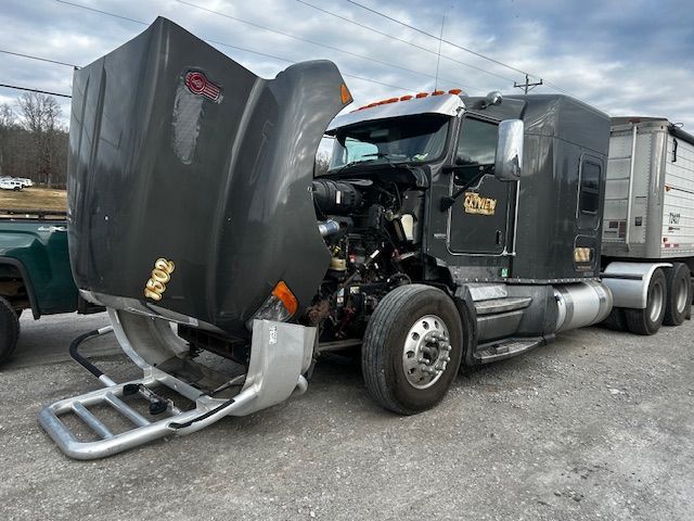 A man is laying on the ground working on a car.