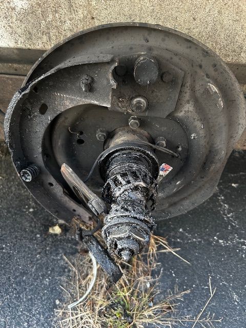A man is kneeling down in the back of a van.