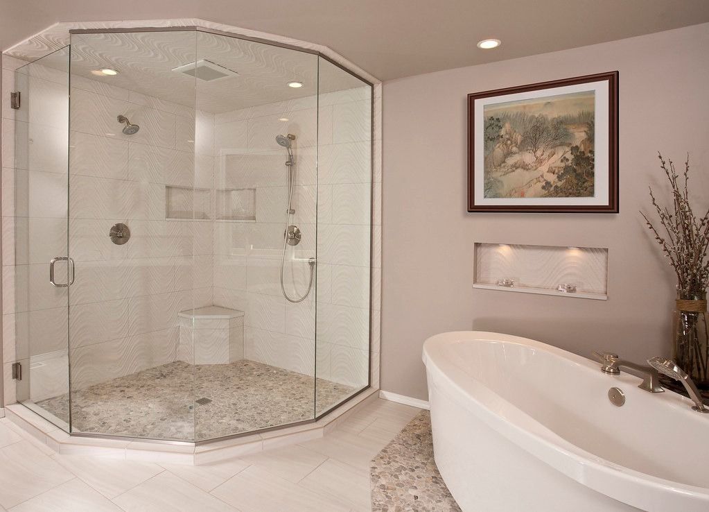 Modern bathroom with a glass shower, white bathtub, and painting on the wall.