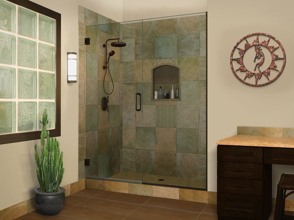 Bathroom with stone tile shower, glass door, decorative wall art, and a potted plant.