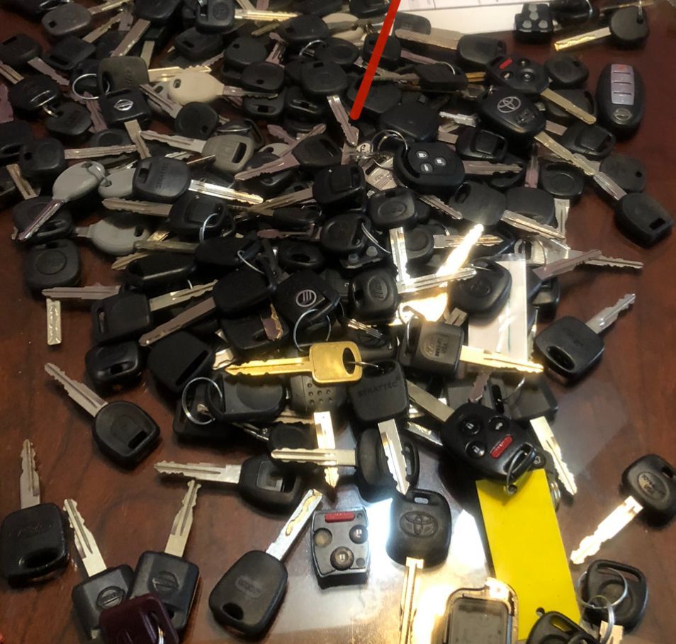 A bunch of keys on a table with one that says ' toyota ' on it