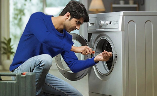 Technician performing Washing Machine Repair Fresno service on a front-loading washer for Bauman's 
