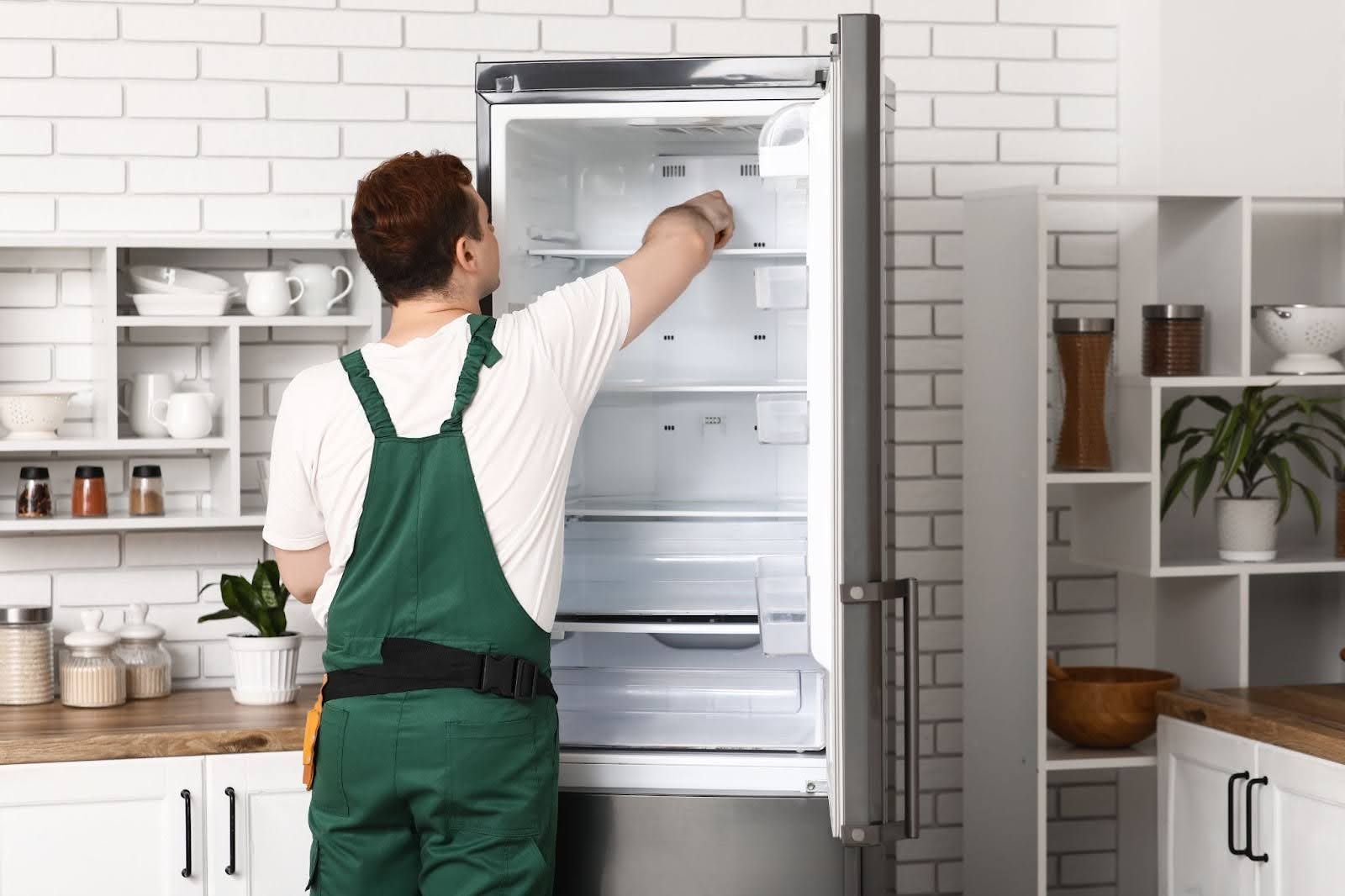 Bauman’s technician is diagnosing a leaking refrigerator in a Fresno kitchen