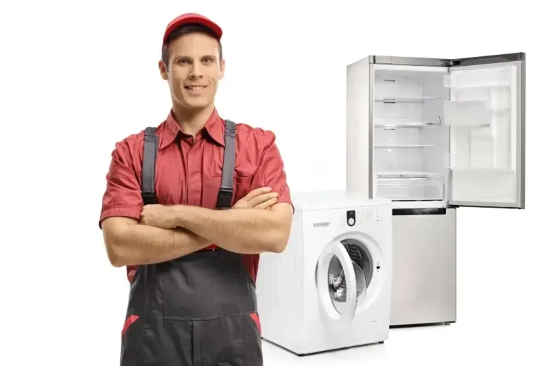 Appliance repair technician fixing refrigerator in Fresno home – Bauman’s Appliance & AC
