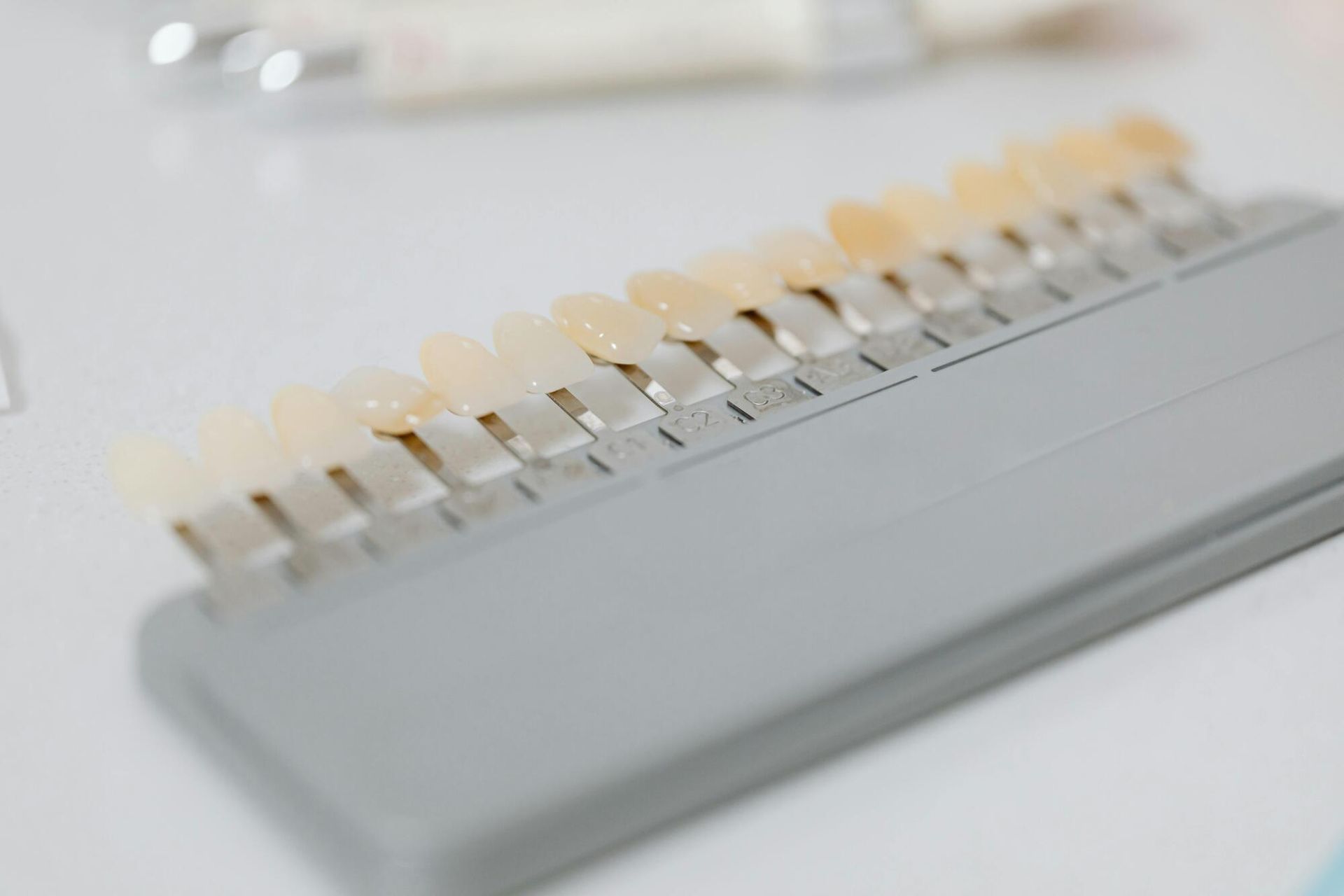 Tooth shade guide on a white surface, used in dentistry to match tooth colors.