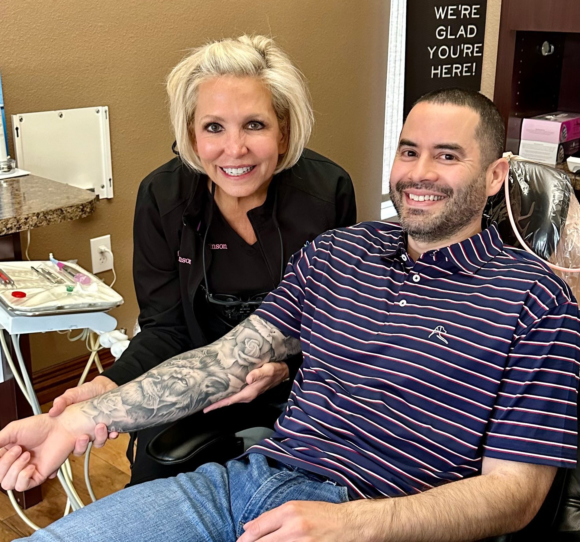 A woman is sitting next to a man in a dental chair.