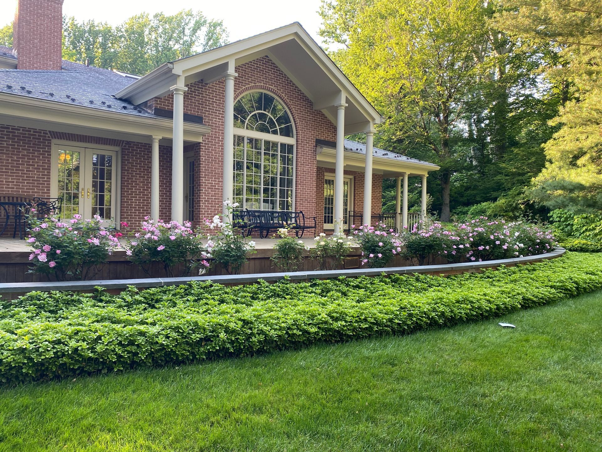 A large brick house with a lush green lawn in front of it.