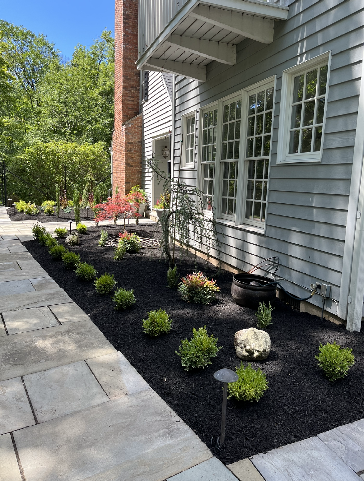 A house with a lot of windows and flowers in front of it.
