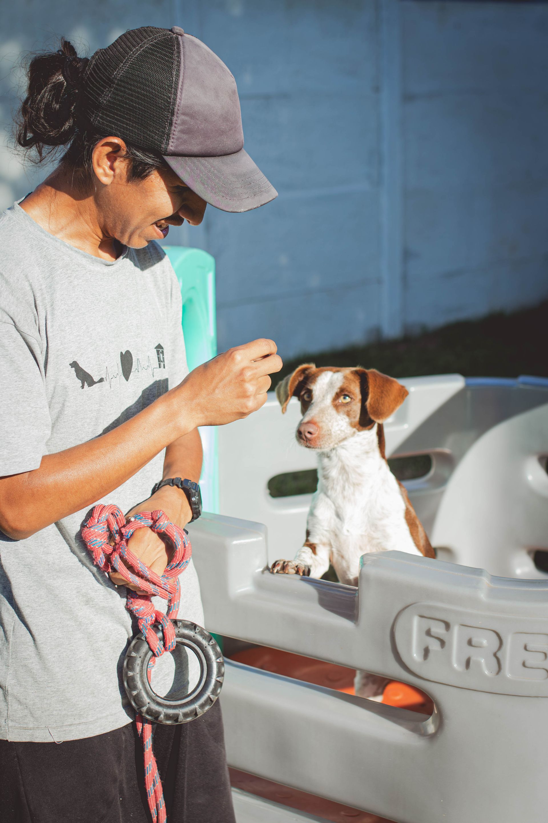 Um homem está de pé ao lado de um cachorrinho na coleira.