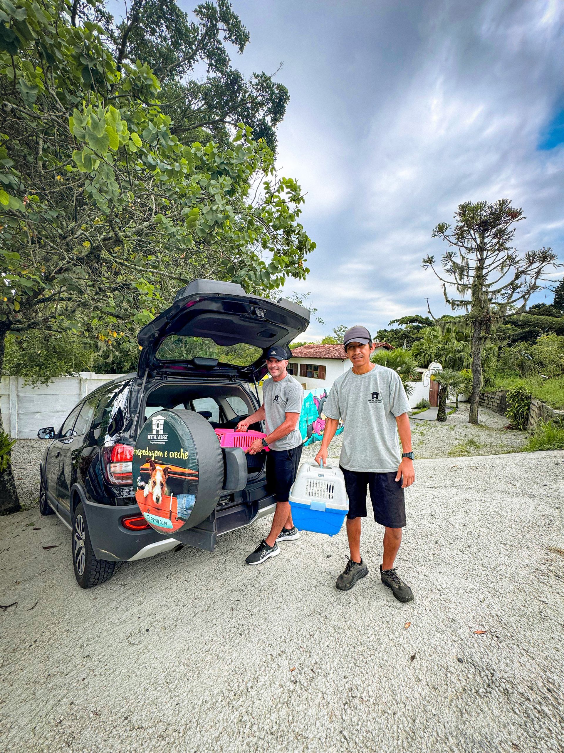 Dois homens estão colocando caixas na parte de trás de um carro.