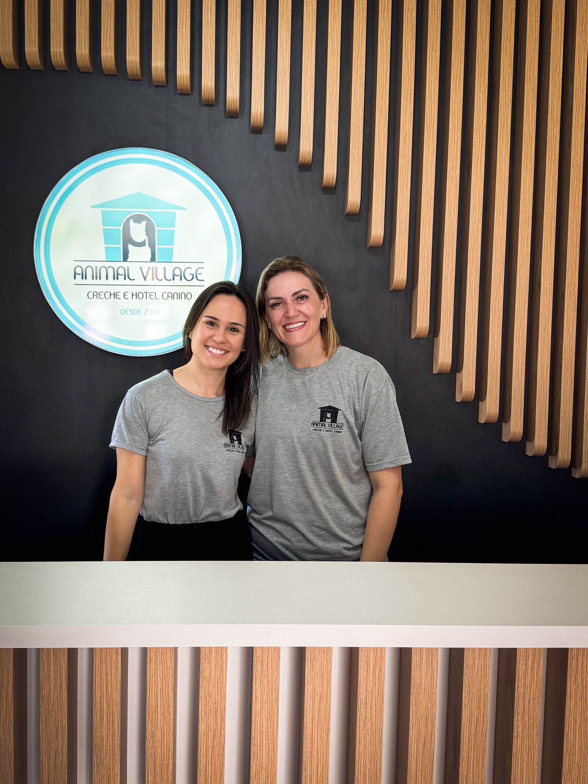 Duas mulheres estão em frente ao balcão da recepção do hotel.