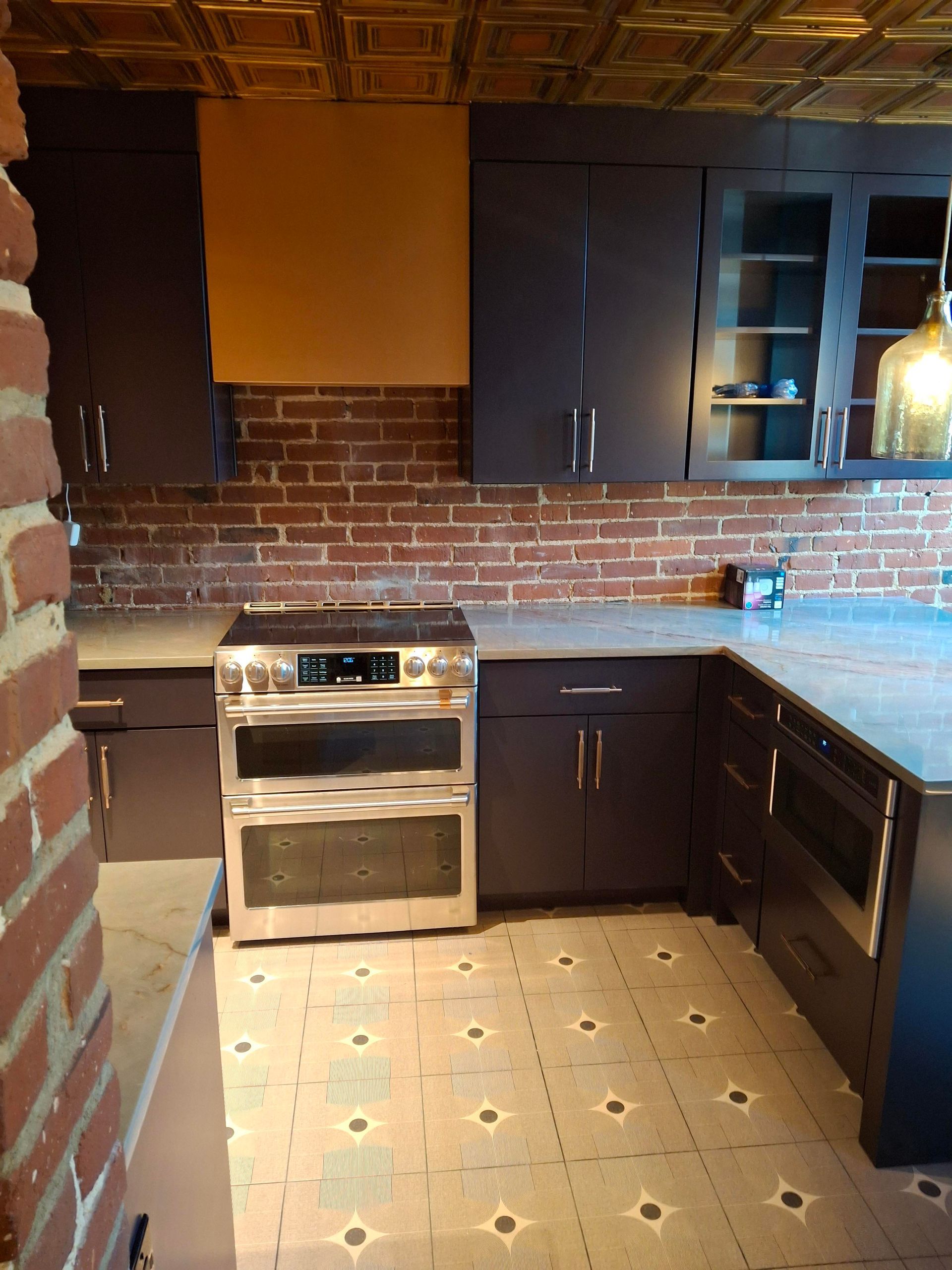 A kitchen with black cabinets and a stove top oven