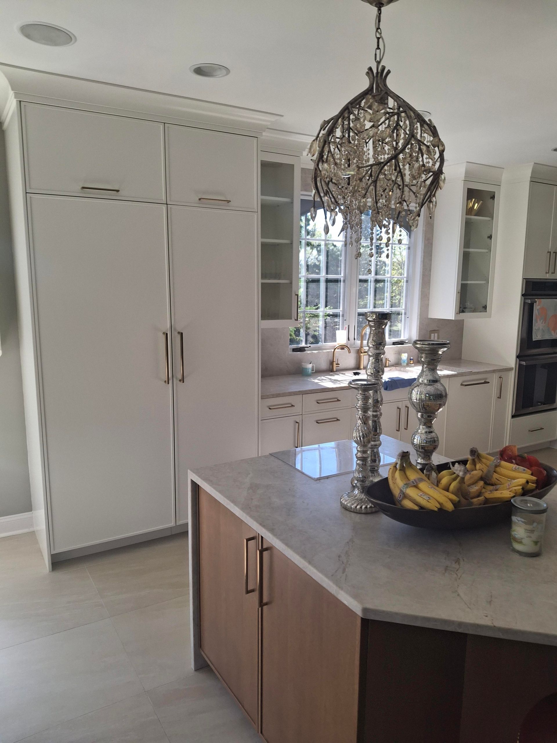 A kitchen with a large island and a chandelier hanging from the ceiling.