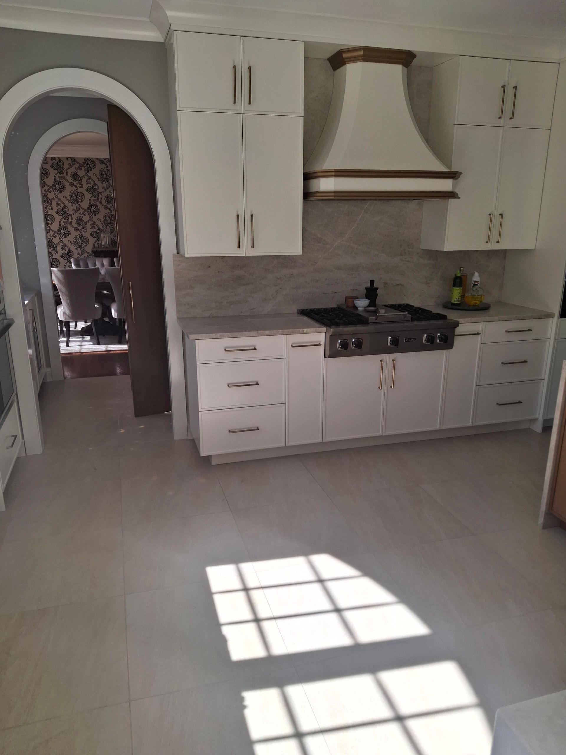 A kitchen with white cabinets and a stove top oven