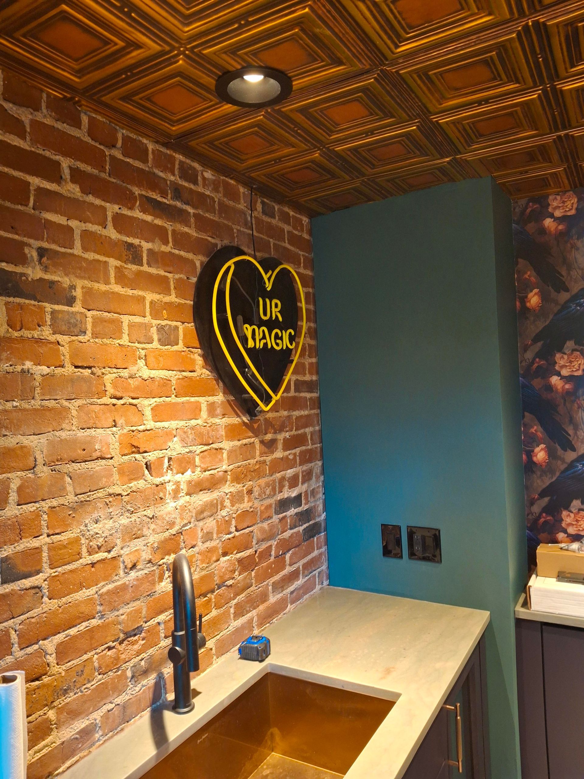 A kitchen with a sink and a brick wall.