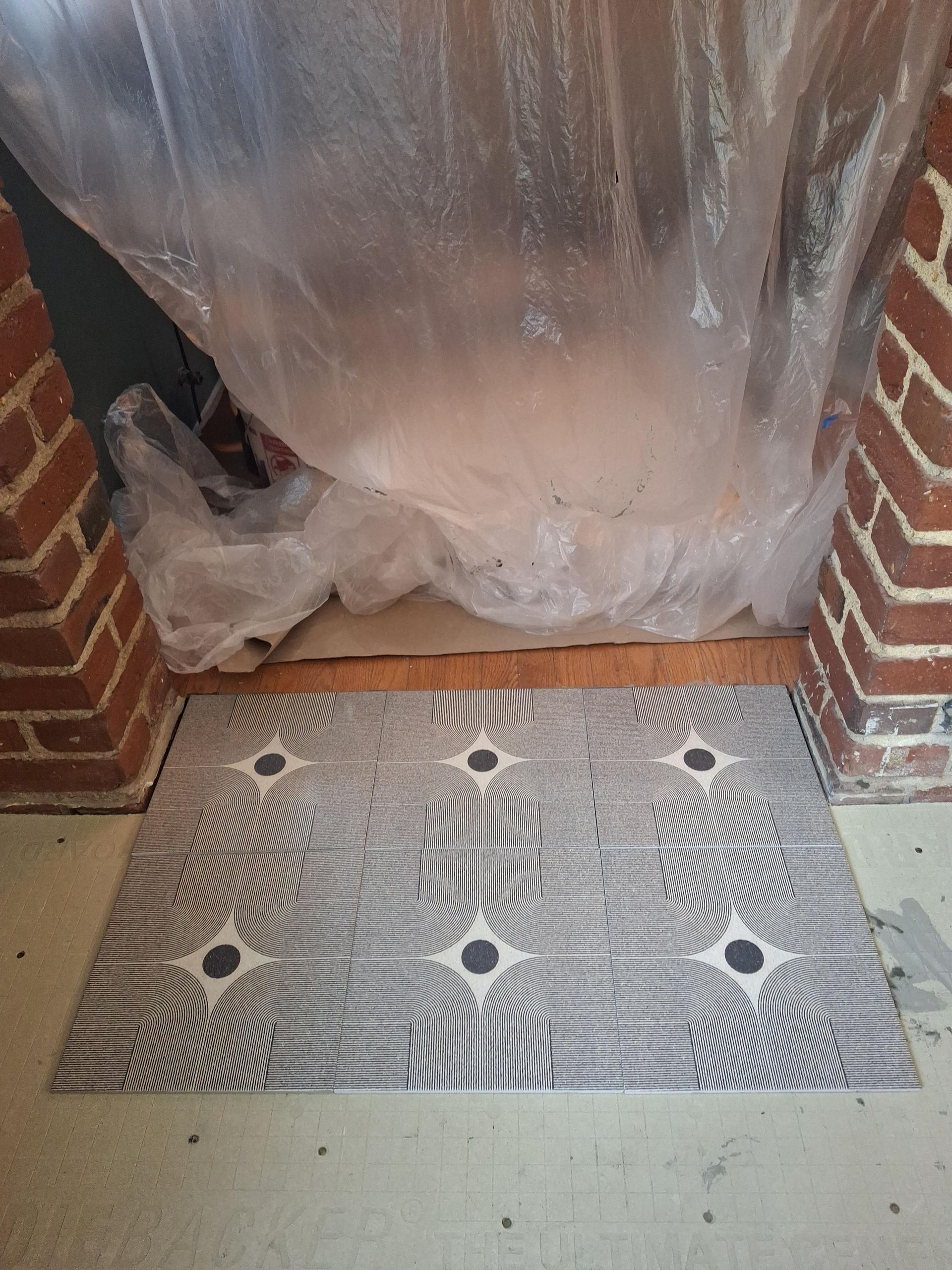 A brick fireplace with a plastic cover over it and a rug on the floor.