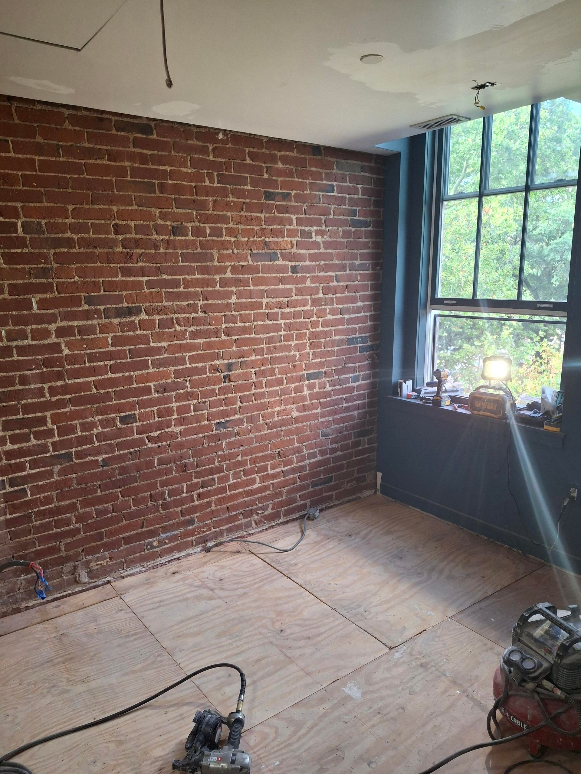 A room with a brick wall and a window