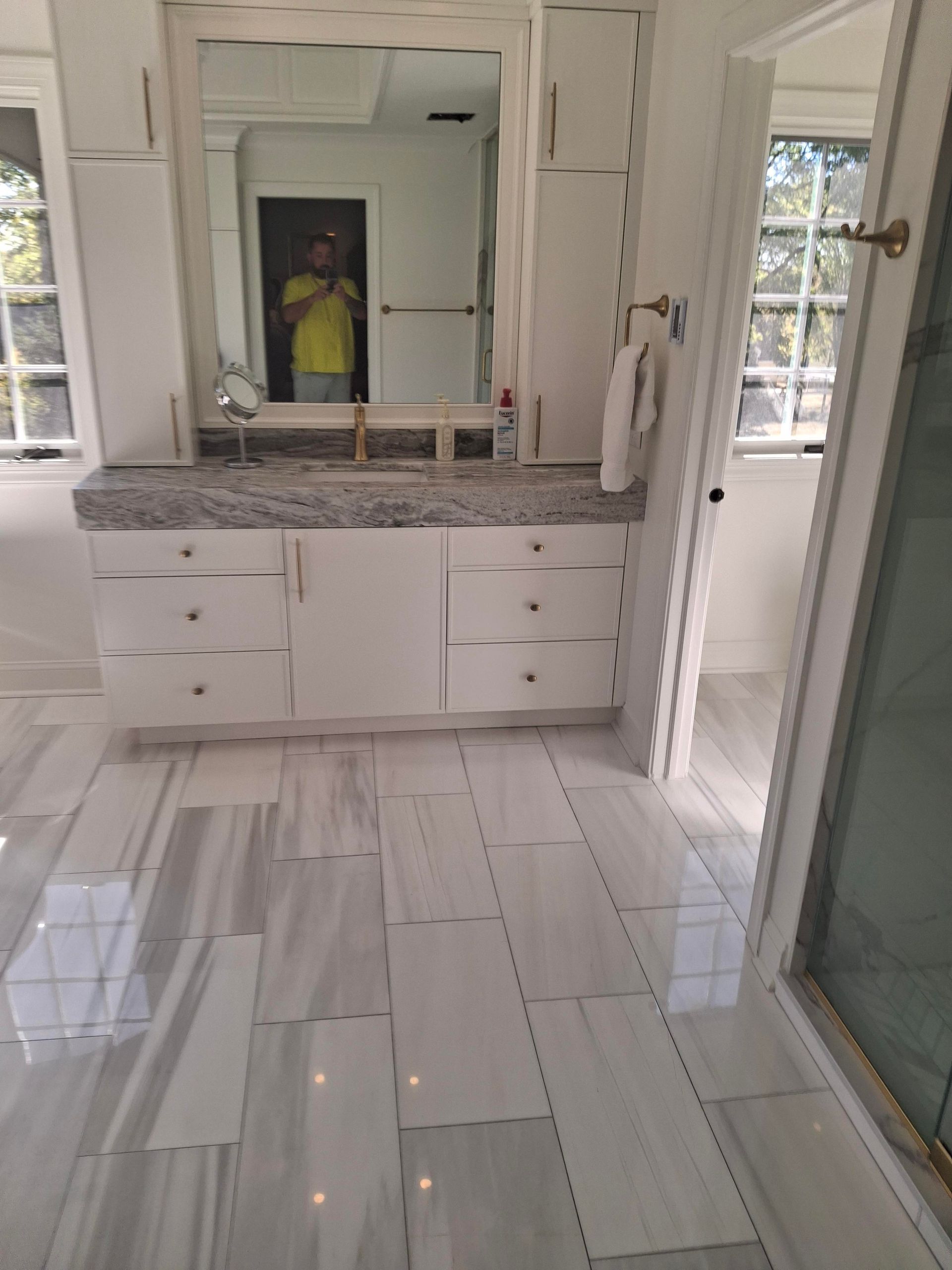 A bathroom with a sink , mirror and tile floor.