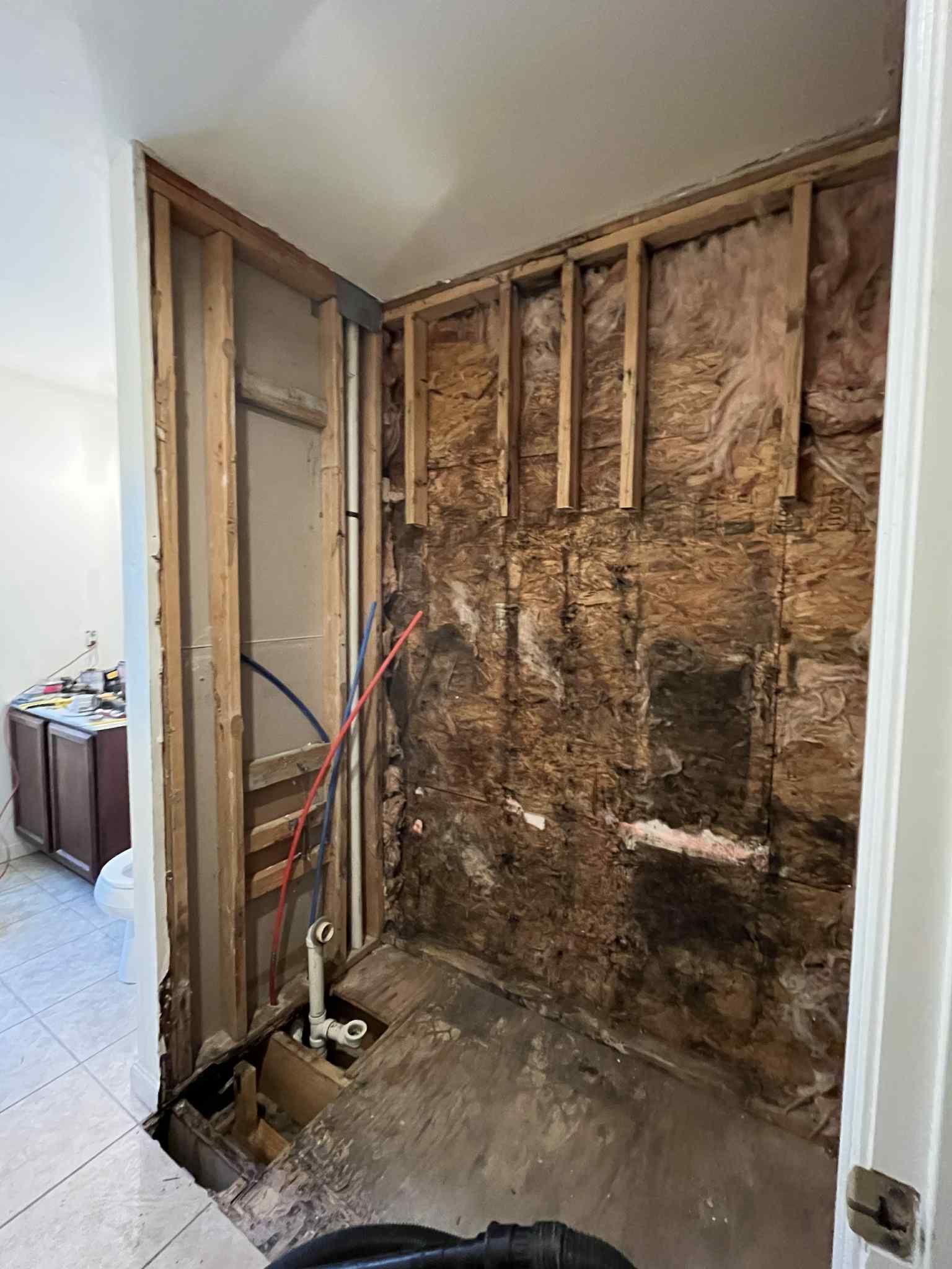 A room with a brick wall and a vacuum cleaner in it.