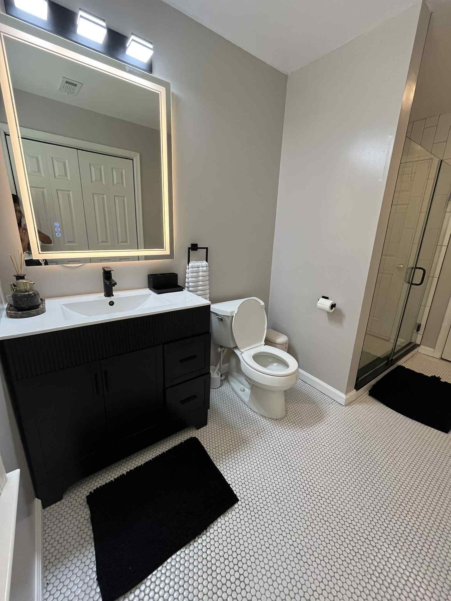 A bathroom with a toilet , sink , and mirror.