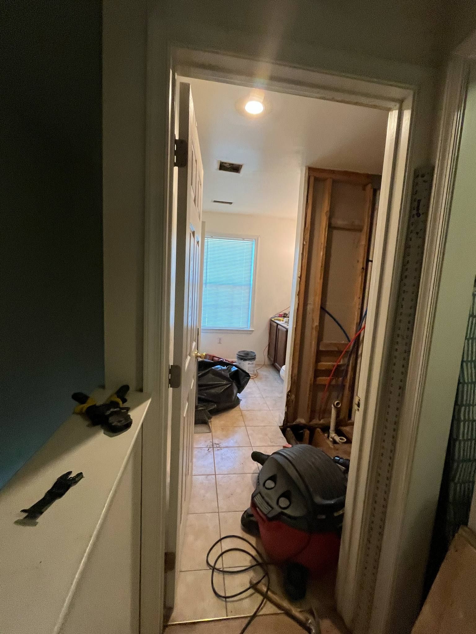 A vacuum cleaner is sitting in a room next to a door.