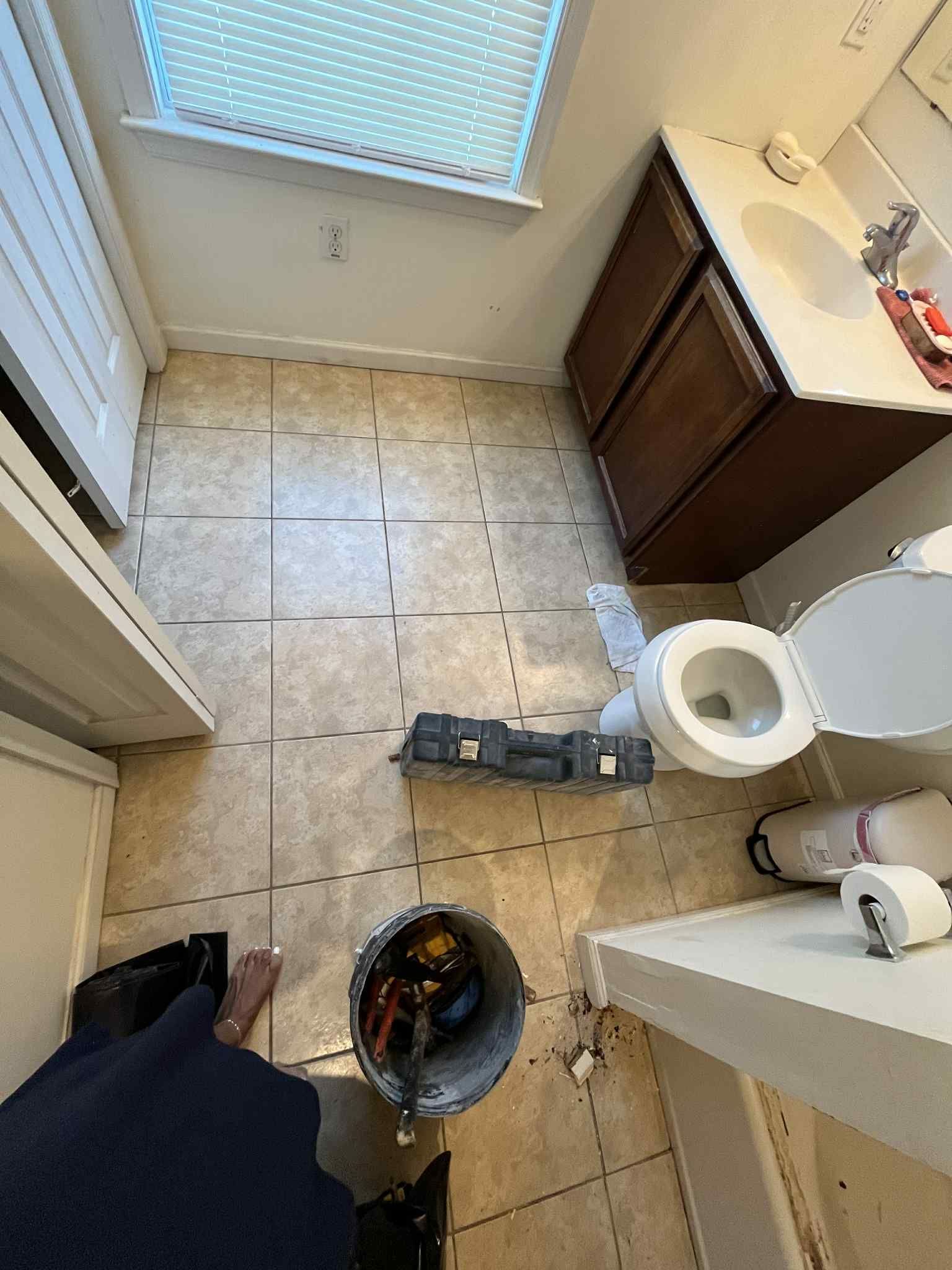 An aerial view of a bathroom with a toilet , sink , and window.