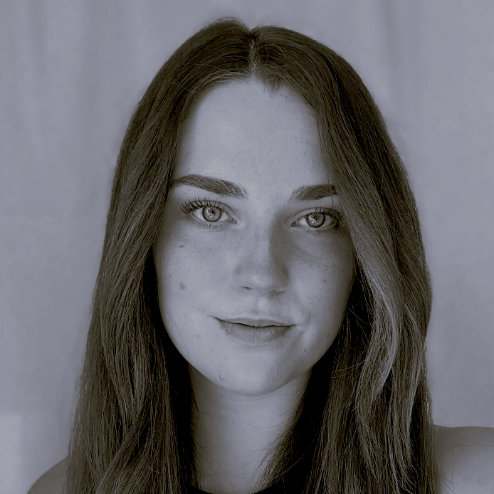 A black and white photo of a woman with long hair and freckles.