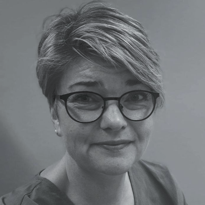 A black and white photo of a woman with long hair and freckles.
