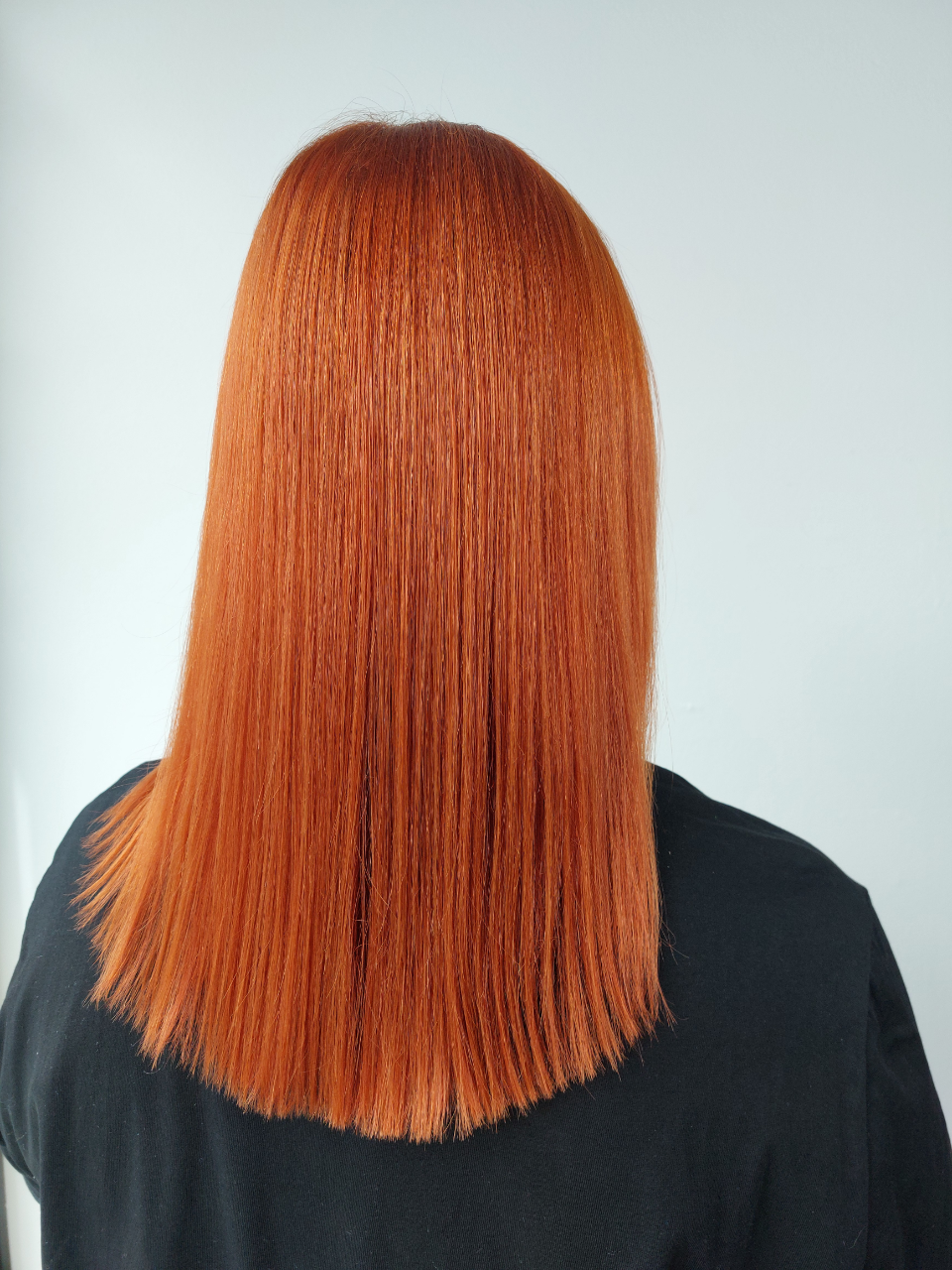 A woman with long red hair is wearing a black shirt.