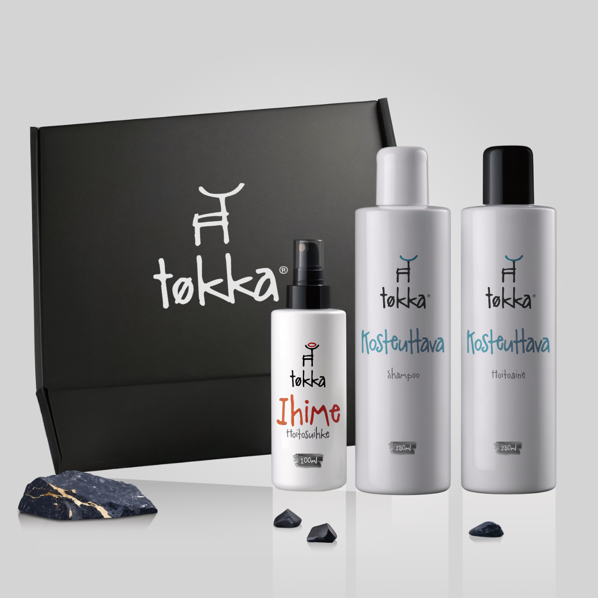 Three bottles of tokka products are displayed in front of a black box