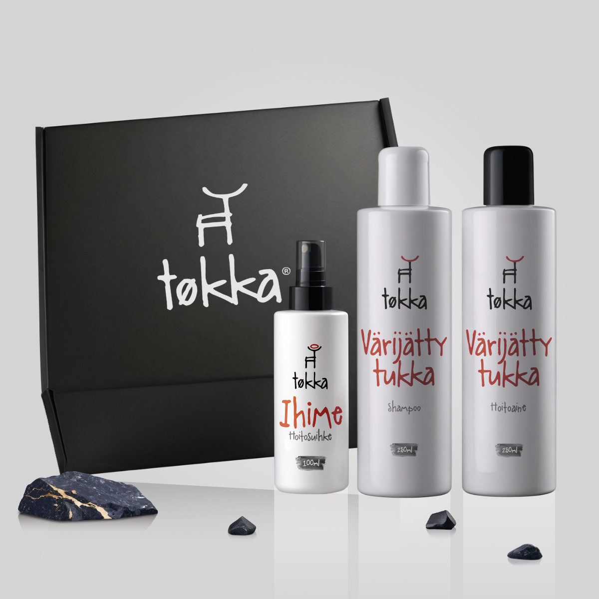 Three bottles of tokka hair products in front of a black box