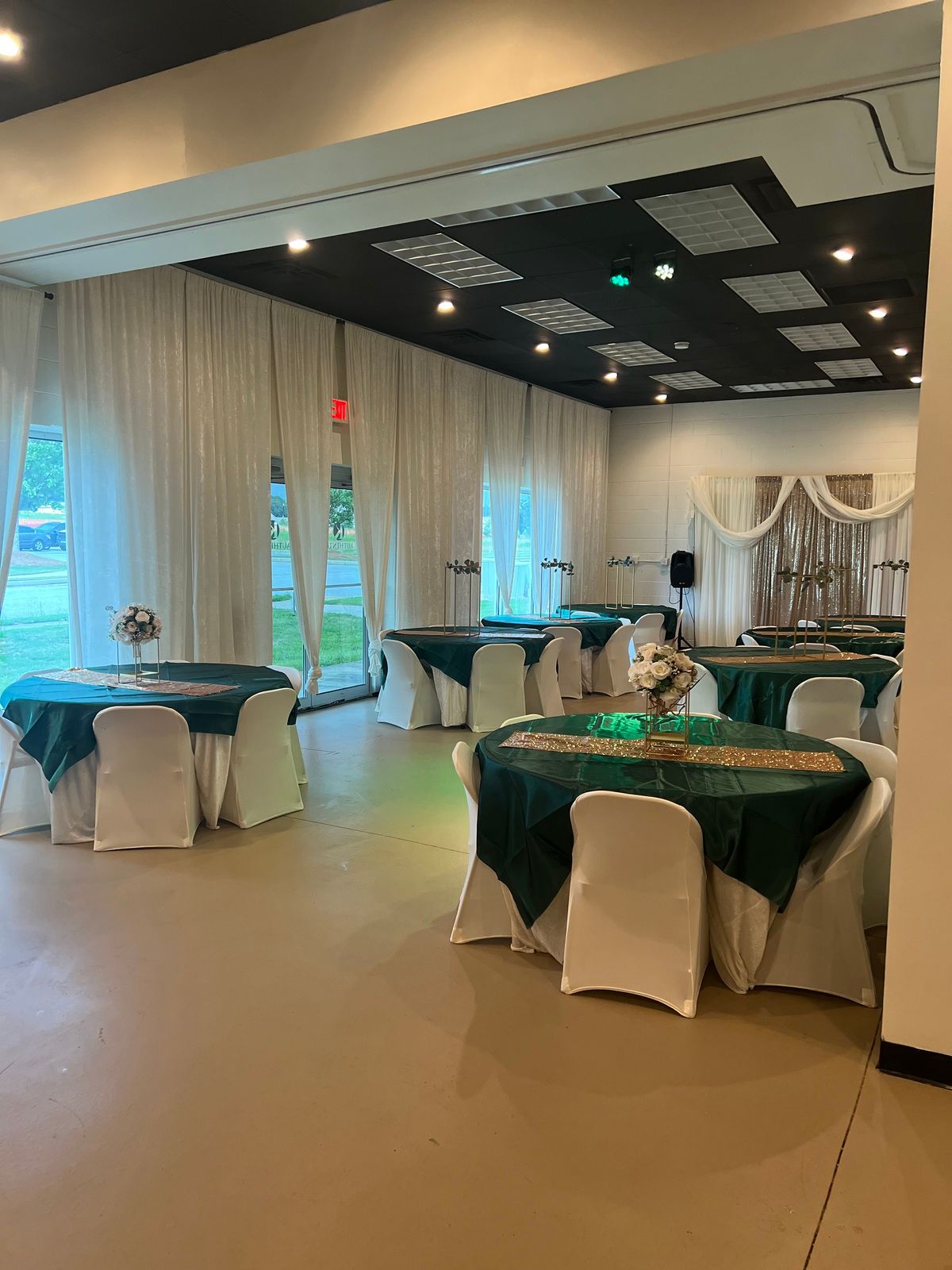 A large room with tables and chairs set up for a wedding reception.