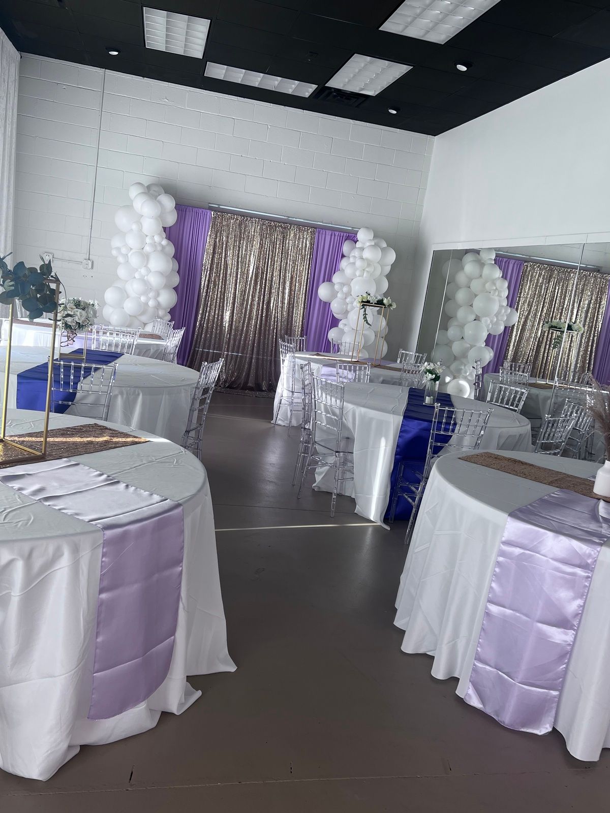 A room filled with tables and chairs and balloons.