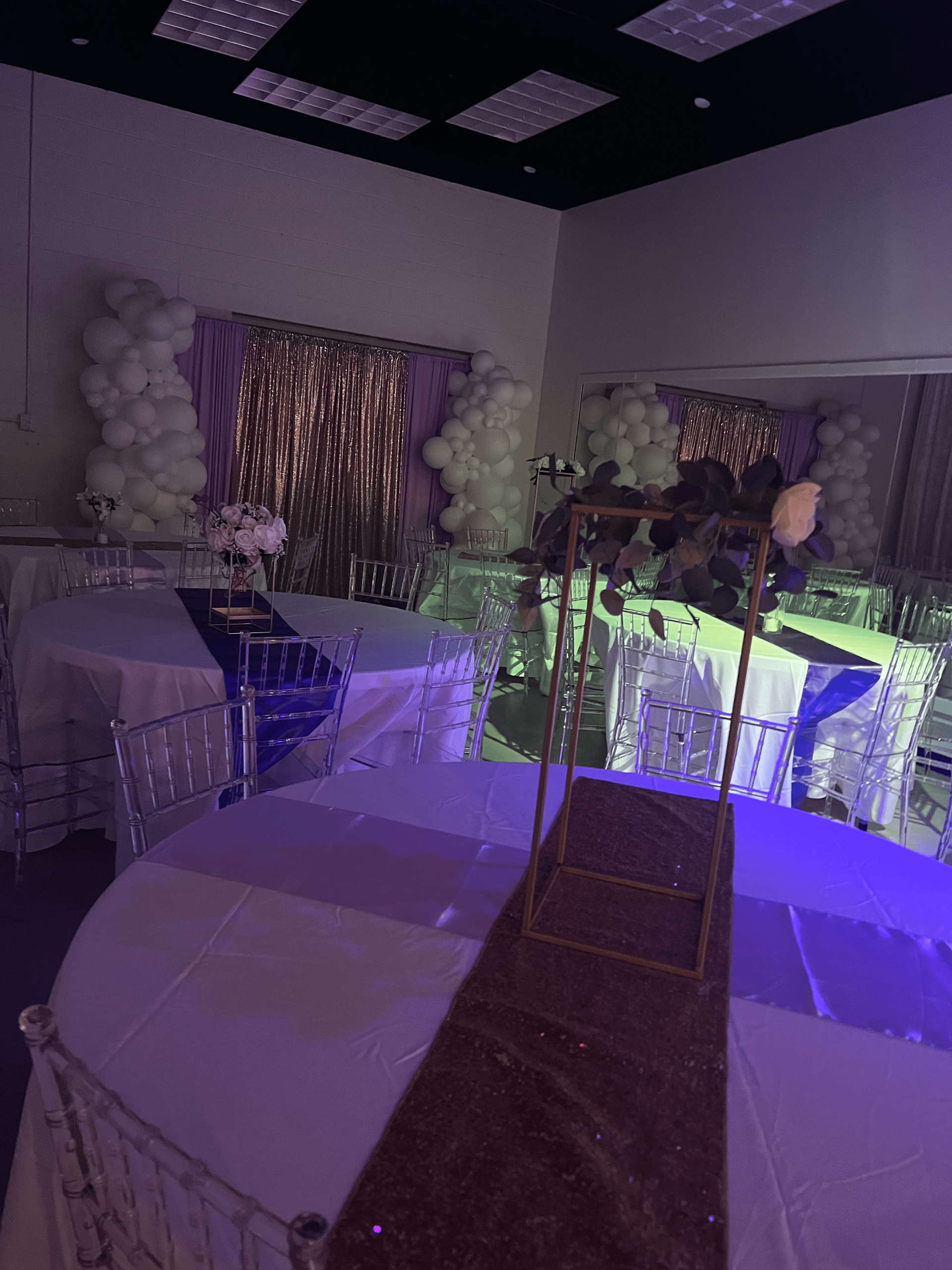 A room filled with tables and chairs and purple lights.