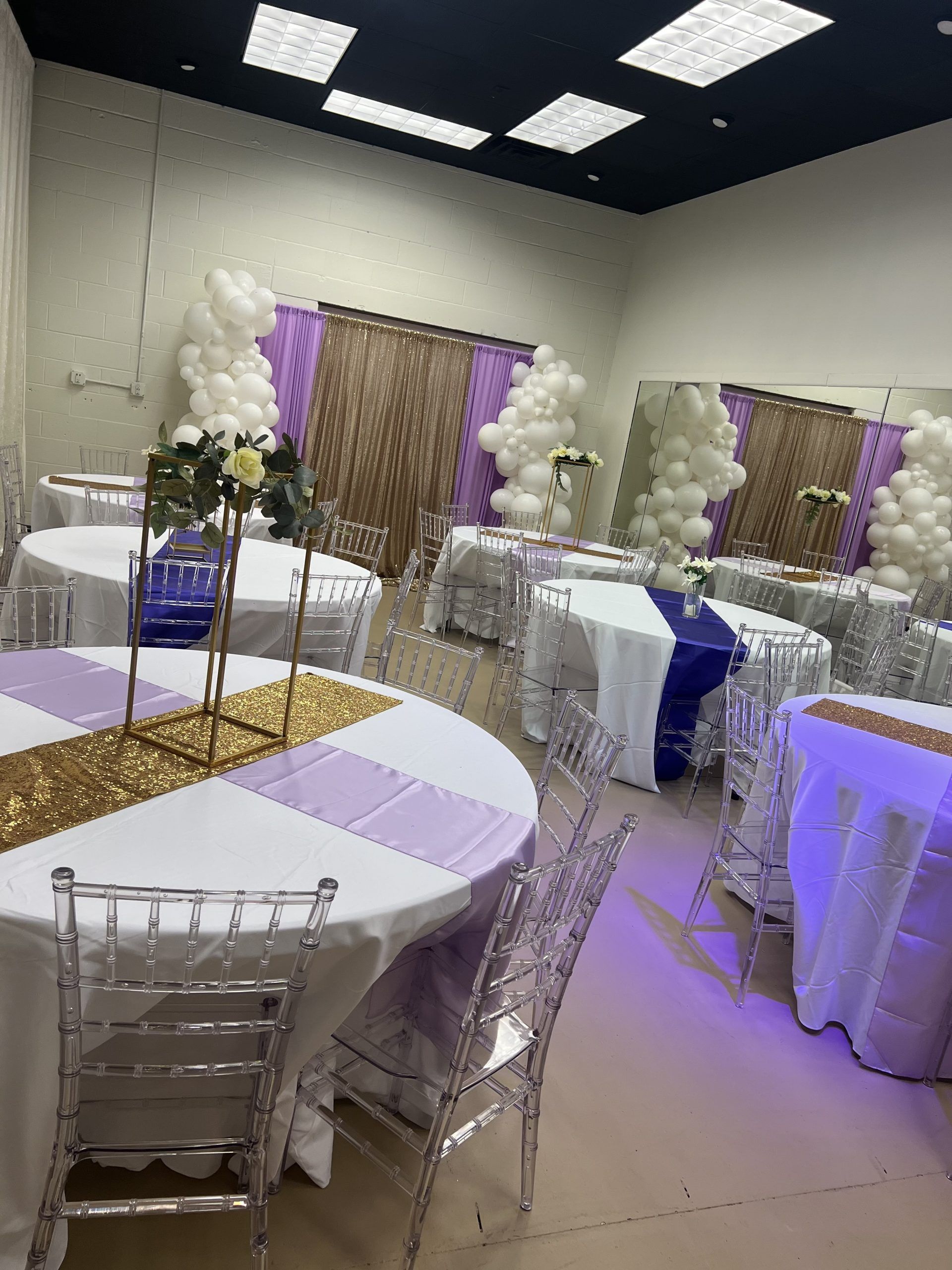 A room filled with tables and chairs and balloons.