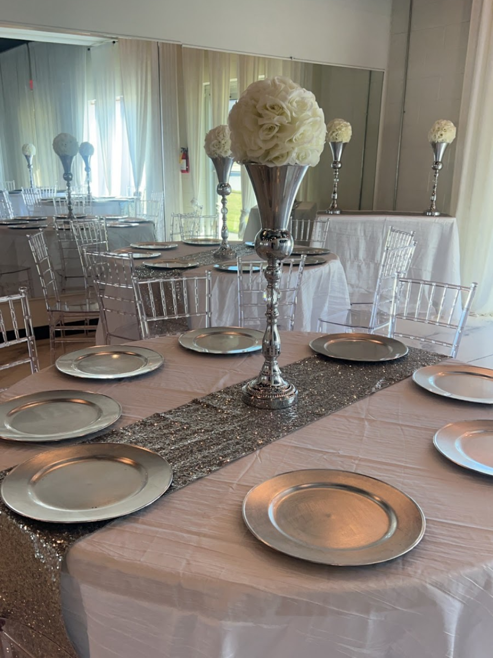 A table with plates and a vase of flowers on it.